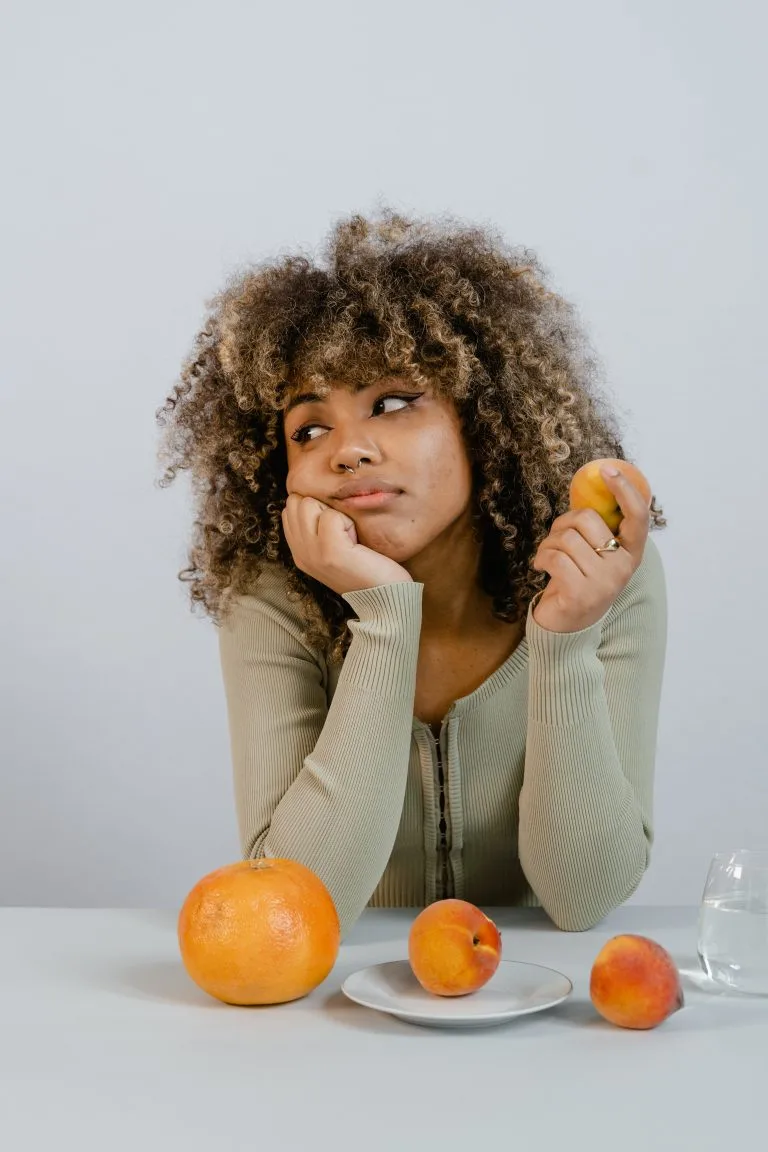 Femme fatiguée d'avoir des douleurs tenant un fruit